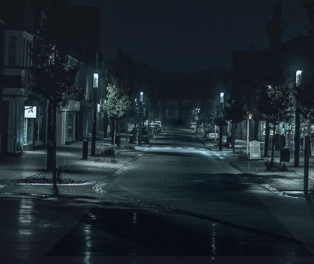 streetlights illuminating an empty intersection at night