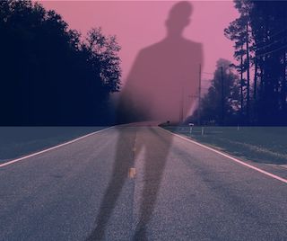 shadow figure standing in the middle of a deserted highway