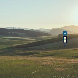 a lone bus stop near a country field